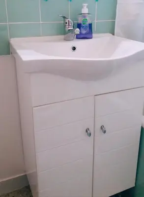 a white bathroom sink with a bottle of soap on it at Athens Apartment 1-min Walk to Kato Patissia Metro in Athens