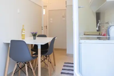 a small kitchen with a white table and chairs at Athens Apartment 1-min Walk to Kato Patissia Metro in Athens