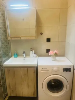 a bathroom with a washing machine and a sink at Cozy flat in Hilton, central Athens, 3' metro, VFM! in Athens