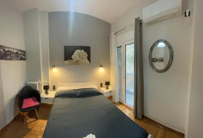 a bedroom with a bed and a mirror on the wall at Cozy flat in Hilton, central Athens, 3' metro, VFM! in Athens