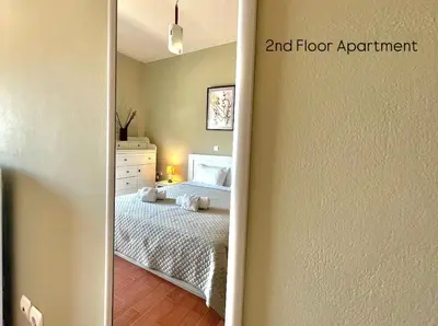 a bedroom with a bed and a mirror at Aggelou Apartments-10 min from Athens airport in Spáta