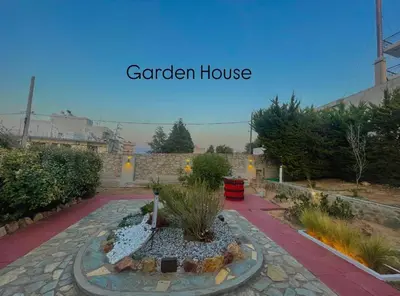 a garden house with a fountain in a courtyard at Aggelou Apartments-10 min from Athens airport in Spáta