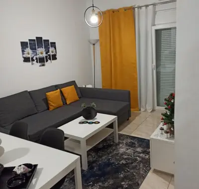 a living room with a couch and a table at Pagrati apartment Διαμέρισμα Παγκράτι in Athens
