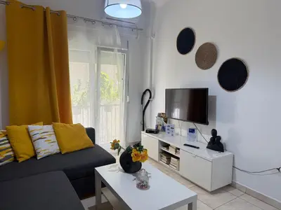a living room with a couch and a tv at Pagrati apartment Διαμέρισμα Παγκράτι in Athens
