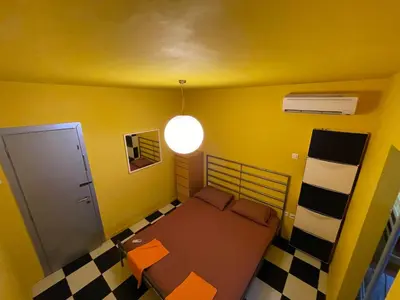 a small room with a bed and a lamp at Architect's summer house by the beach in Porto Rafti
