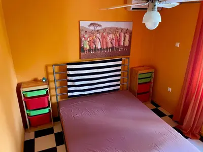 a bedroom with a bed and a painting on the wall at Architect's summer house by the beach in Porto Rafti