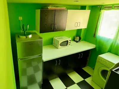 a small kitchen with green walls and a microwave at Architect's summer house by the beach in Porto Rafti