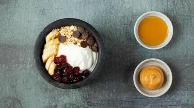 a bowl of yogurt with berries and a bowl of orange juice at The Newel Psychiko in Athens