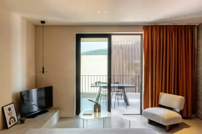 a living room with a television and a table with a chair at The Newel Psychiko in Athens