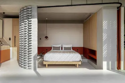 a bedroom with a bed and a brick wall at The Newel Psychiko in Athens