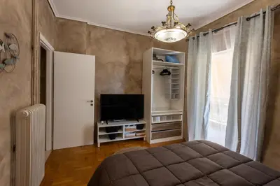 a bedroom with a bed and a tv and a window at MS APARTMENT in Athens