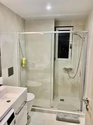 a white bathroom with a shower and a toilet at Fab New Flat in Central Athens w/ Acropolis Views in Athens