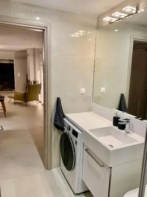 a bathroom with a washing machine and a sink at Fab New Flat in Central Athens w/ Acropolis Views in Athens