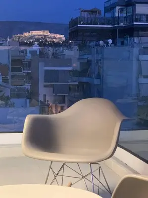 a white chair sitting in front of a window at Fab New Flat in Central Athens w/ Acropolis Views in Athens