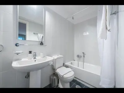 a white bathroom with a sink and a toilet and a tub at Adelos III Bloom Villa 5BR 360m - Sauna - Rooftop in Athens