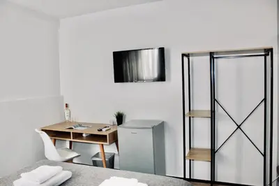a room with a desk and a table with a refrigerator at Navitas House in Athens