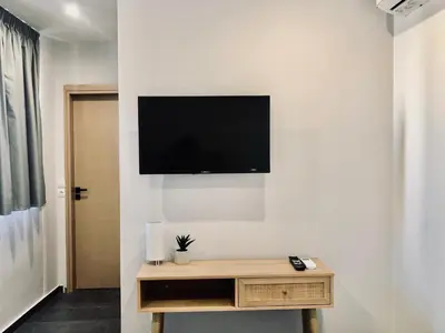 a living room with a tv on a wall at Navitas House in Athens