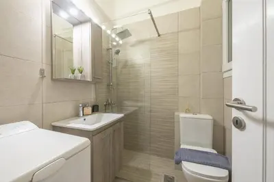 a bathroom with a toilet and a sink at City Suite by Cloudkeys in Athens
