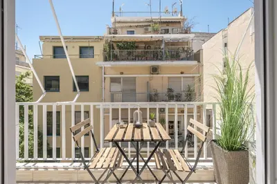 a patio with a table and chairs on a balcony at City Suite by Cloudkeys in Athens