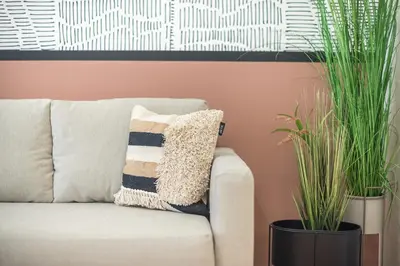 a couch with two potted plants in a living room at City Suite by Cloudkeys in Athens
