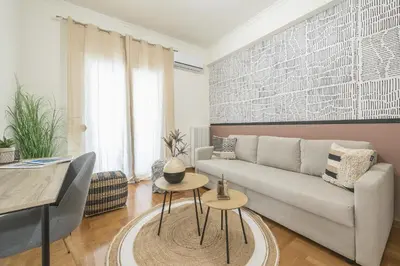 a living room with a couch and a table at City Suite by Cloudkeys in Athens