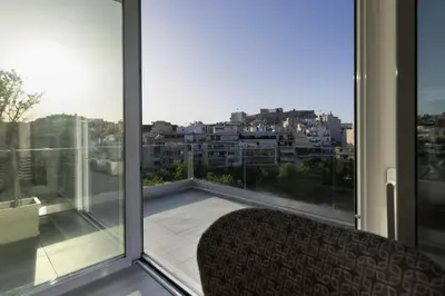 a balcony with a chair and a view of a city at Über Lux 2 BR New Penthouse with Acropolis View in Athens