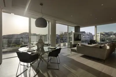 a living room with a table and chairs and a couch at Über Lux 2 BR New Penthouse with Acropolis View in Athens