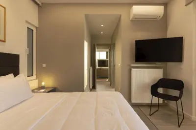 a bedroom with a bed with a television and a chair at Über Lux 2 BR New Penthouse with Acropolis View in Athens