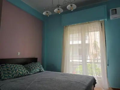 a bedroom with a bed and a large window at Evangelli Apartment- An oasis inside the center of Athens in Athens