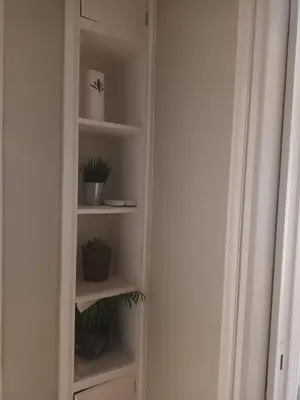 a white book shelf with potted plants in it at Evangelli Apartment- An oasis inside the center of Athens in Athens