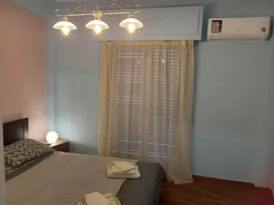 a bedroom with a bed and a window with lights at Evangelli Apartment- An oasis inside the center of Athens in Athens