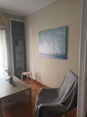 a living room with a painting of sailboats on the wall at Evangelli Apartment- An oasis inside the center of Athens in Athens