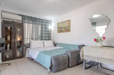 a bedroom with a bed and a couch at Flat w Parking at Flisvos Marina & SNFCC, 300mbps in Athens
