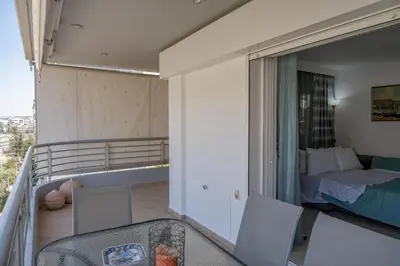 a room with a balcony with a bed and a bed sqor at Flat w Parking at Flisvos Marina & SNFCC, 300mbps in Athens