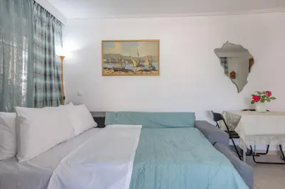 a bedroom with a bed and a table with a table sidx sidx at Flat w Parking at Flisvos Marina & SNFCC, 300mbps in Athens