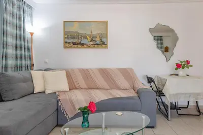 a living room with a couch and a table at Flat w Parking at Flisvos Marina & SNFCC, 300mbps in Athens