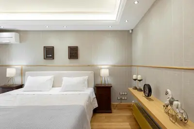 a bedroom with a large white bed and two lamps at Vouliagmeni's Elegance by Acropolis Suites in Athens