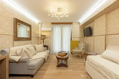 a living room with a couch and a table at Vouliagmeni's Elegance by Acropolis Suites in Athens