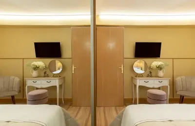 a hospital room with two beds and two mirrors at Vouliagmeni's Elegance by Acropolis Suites in Athens