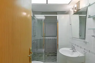 a bathroom with a shower and a sink and a toilet at Vouliagmeni's Elegance by Acropolis Suites in Athens