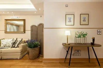 a living room with a couch and a table with a mirror at Vouliagmeni's Elegance by Acropolis Suites in Athens