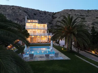 a house with a swimming pool and a palm tree at Kamariyo Athens Riviera by A&D Properties in Palaiá Fókaia