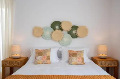 a bedroom with a white bed with two tables and two lamps at Kamariyo Athens Riviera by A&D Properties in Palaiá Fókaia