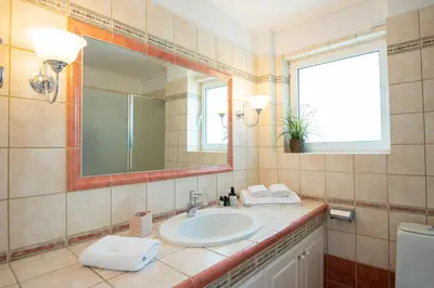 a bathroom with a sink and a mirror at Kamariyo Athens Riviera by A&D Properties in Palaiá Fókaia