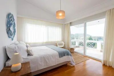 a bedroom with a bed and a large window at Kamariyo Athens Riviera by A&D Properties in Palaiá Fókaia