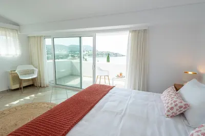 a bedroom with a bed and a view of the ocean at Kamariyo Athens Riviera by A&D Properties in Palaiá Fókaia