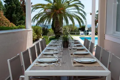 a long table with plates and glasses on a patio at Kamariyo Athens Riviera by A&D Properties in Palaiá Fókaia