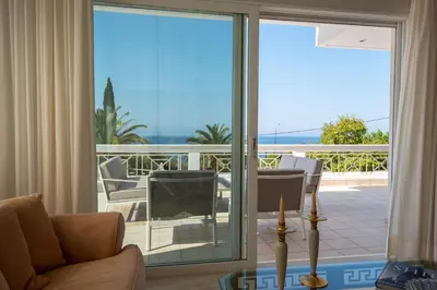 a living room with a sliding glass door to a balcony at Kamariyo Athens Riviera by A&D Properties in Palaiá Fókaia
