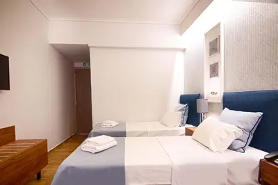 two beds in a hotel room with white and blue at FALIREON HOTEL in Athens
