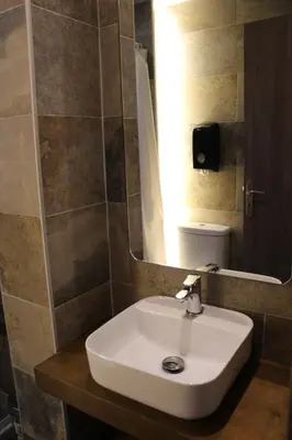 a bathroom with a white sink and a mirror at FALIREON HOTEL in Athens